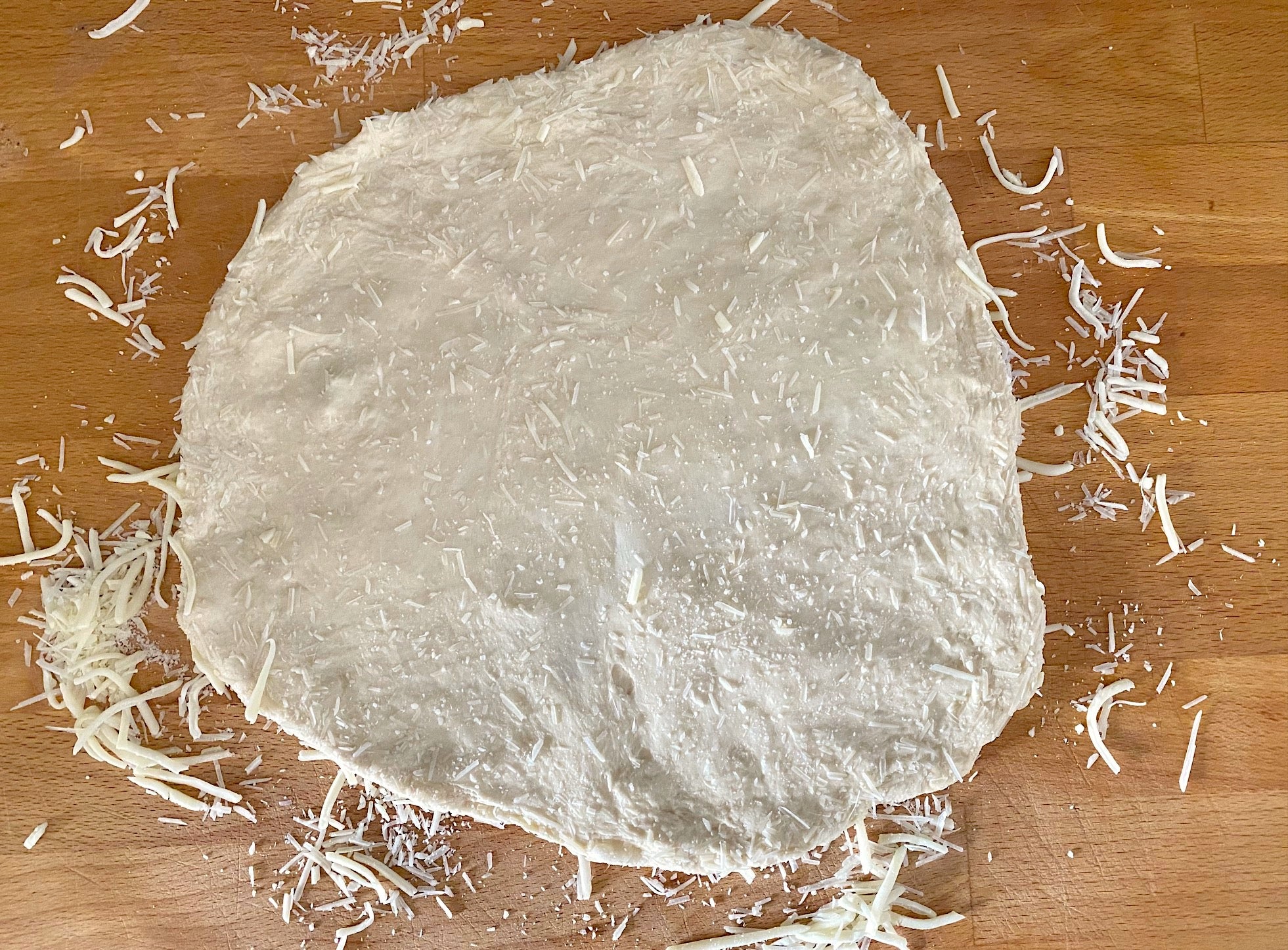 Dough with cheese pressed into both sides, but extra-heavy on the bottom. (Photo: Allie Chanthorn Reinmann)