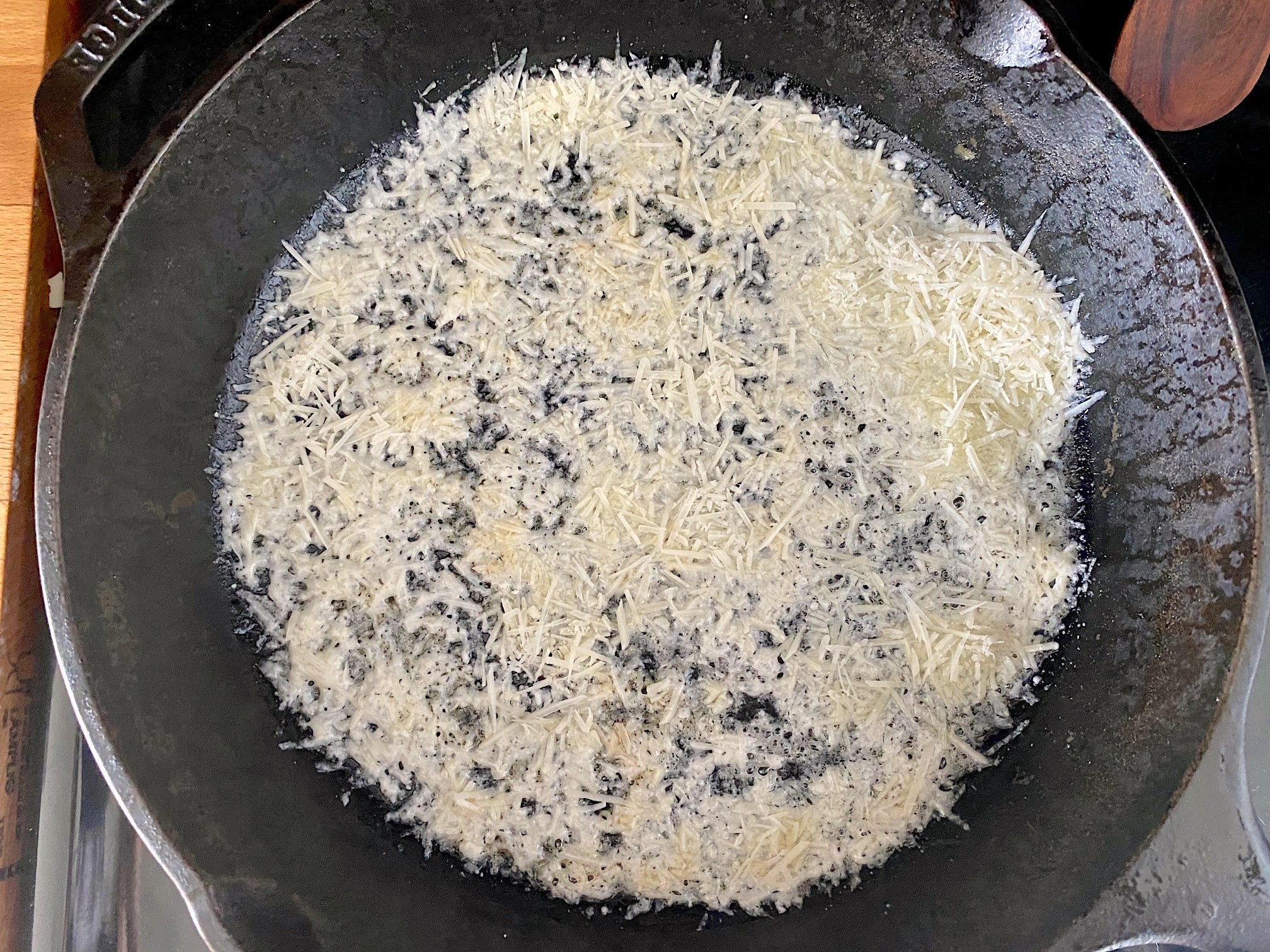 Parmesan sprinkled into the bottom of the skillet. (Photo: Allie Chanthorn Reinmann)
