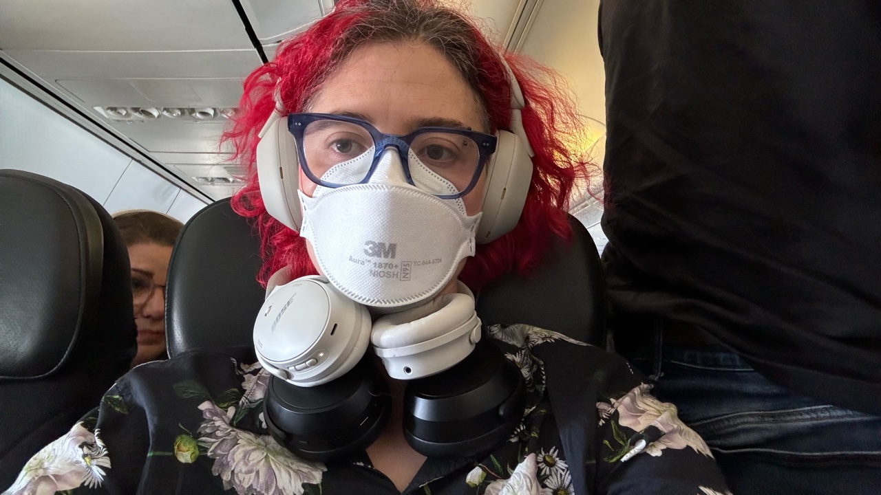 A woman testing headphones on a plane
