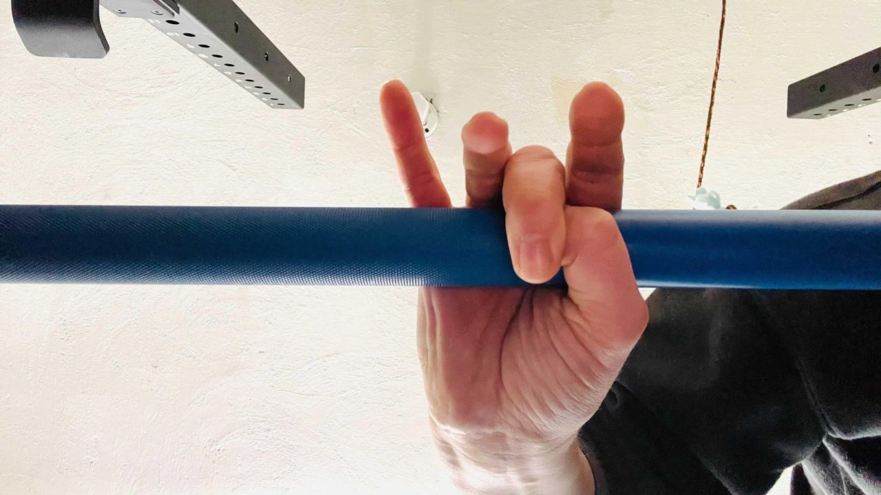Here's where I place my thumb in the hook grip. After setting my thumb in place under my middle finger, I'll wrap the rest of my fingers comfortably around the bar.  (Photo: Beth Skwarecki)