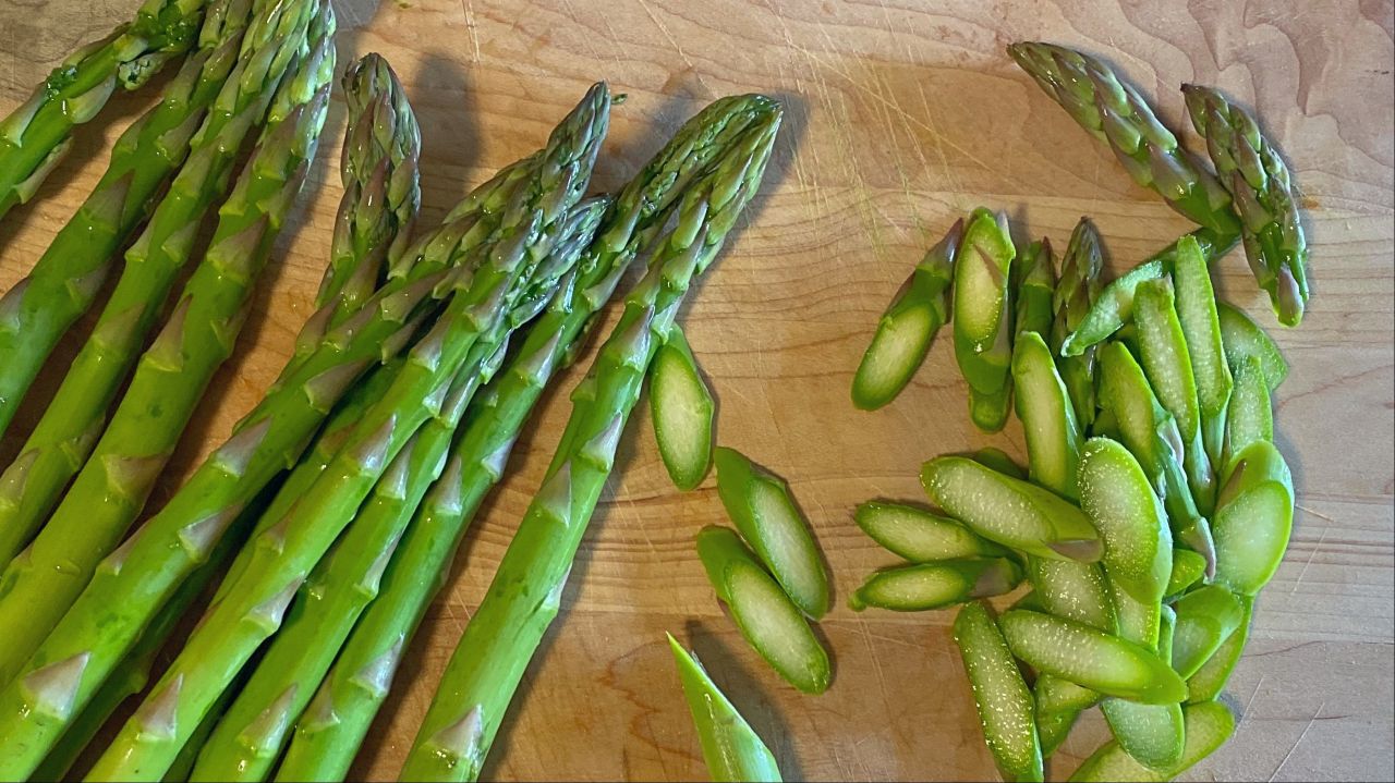 Asparagus stalks and slices on a wooden cutting board. (Photo: Claire Lower)